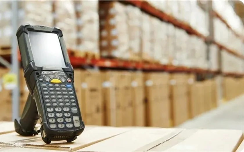 A rugged handheld barcode scanner in a warehouse